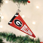 Red and black ornament shaped like a pennant with 'Bulldogs' text, hanging on a Christmas tree.