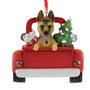 German Shepherd Dog ornament in a red truck with Christmas tree and decorations on a white background