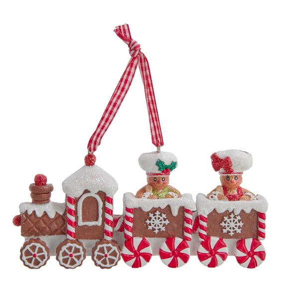 Ornament shaped like a gingerbread train with icing details, peppermint wheels, and gingerbread boy and girl figures riding in the train cars.