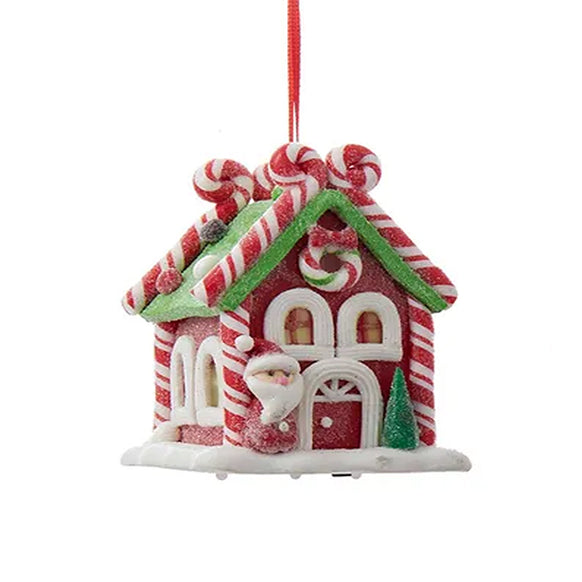 Decorative Christmas ornament shaped like a gingerbread house with candy cane details on a white background.