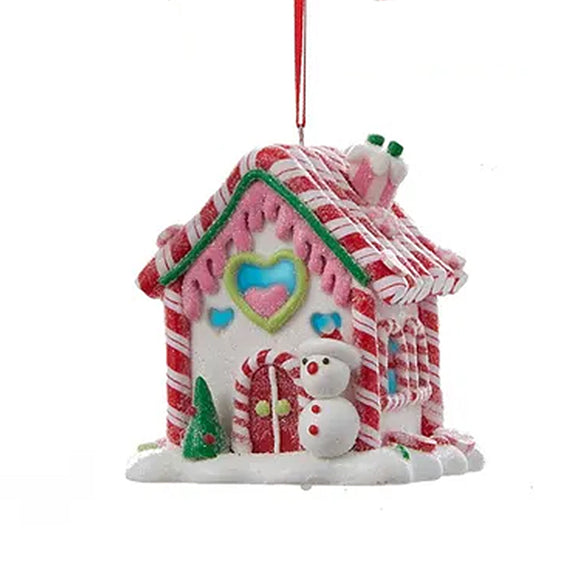 Decorative gingerbread house ornament with candy cane roof and snowman on a white background