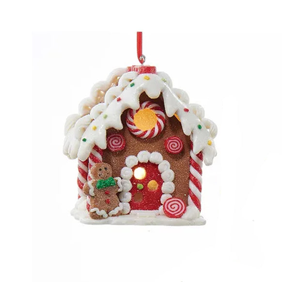 Decorative gingerbread house ornament with candy details on a white background