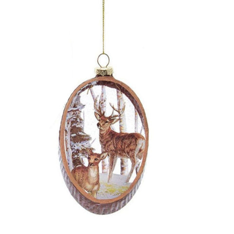 Oval glass ornament with a buck and doe standing in a snowy woodland scene, framed with a rustic wood-look border.