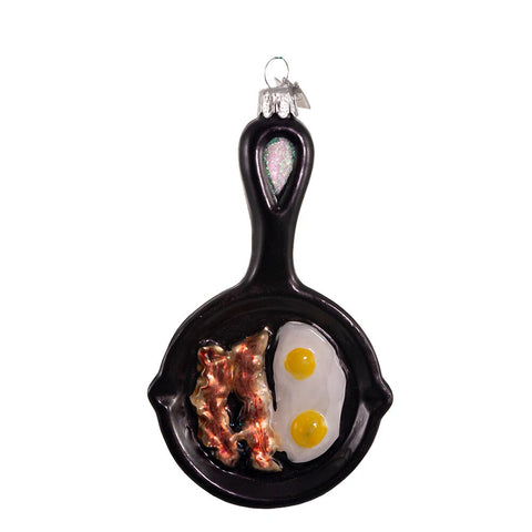 Breakfast skillet glass ornament with black frying pan, bacon, eggs, glitter detail on the handle, silver cap, and hanging loop.
