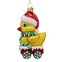 Glass duck ornament wearing a red Santa hat and green striped scarf while riding in a red cart with snowflake wheels.