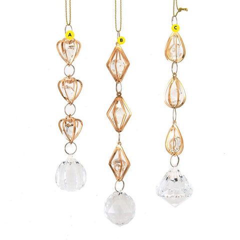 Clear faceted drop ornaments with gold-tone metal frames, shown in heart, diamond, and teardrop styles with hanging crystal accents.