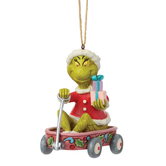 Front view of licensed Jim Shore Grinch in Wagon Ornament featuring the Grinch in a Santa suit holding wrapped presents while sitting in a festive wagon.