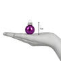 Size reference image for the Old World Christmas 1" Halloween ball ornament set, showing a purple mini ball ornament resting on an open hand with a 1 inch size marker beside it.