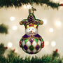 Decorative Christmas ornament shaped like a snowman with a jester hat, hanging on a tree.