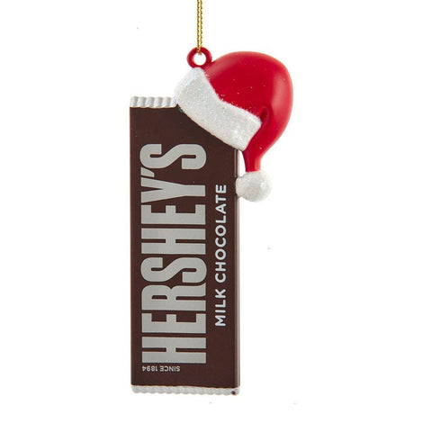 Hershey’s™ milk chocolate bar ornament with a red Santa hat and glittery white trim, hanging from a gold cord.