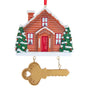 Personalized home with key ornament with a snow-covered brown house, decorated Christmas trees, and a hanging gold key below.
