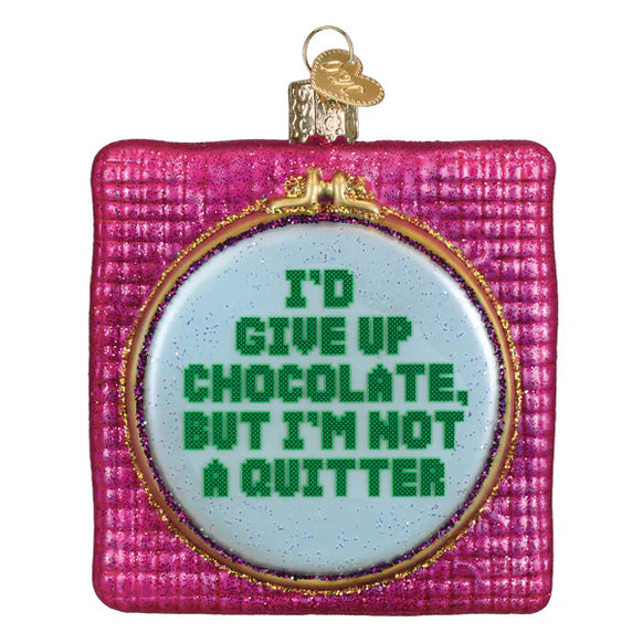 Decorative ornament with text 'I'd give up chocolate, but I'm not a quitter' on a pink background