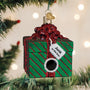 Christmas ornament shaped like a green gift box with a red ribbon and 'Junk in the box' tag, hanging on a tree.