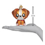 Glass ornament of a Kawaii brown and white dog with a red collar on a white background with a hand to show size 3.5 inches