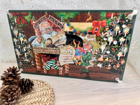 Mini Glass Ornament Advent Calendar in a decorative box featuring Santa, an elf, and numbered doors for each day of Advent.