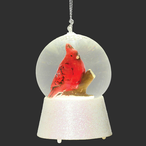 LED cardinal waterglobe ornament with a red cardinal on a branch inside a clear globe and a white glittered base, shown illuminated.