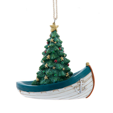 Christmas ornament with a decorated green tree inside a white boat with blue trim and an anchor detail on the side.