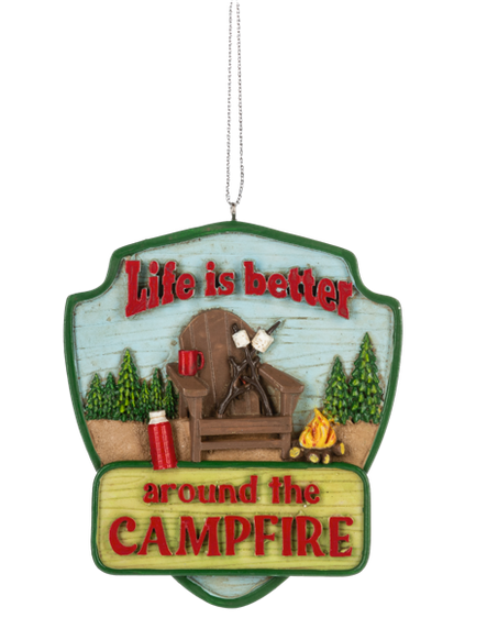 Campfire ornament with a green sign design, Adirondack chair, roasting marshmallows, campfire, trees, and the phrase “Life is better around the campfire.”