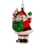 Back view of a lighted glass Santa ornament with a green gift bag filled with candy canes, wrapped presents, and glittered accents.