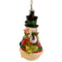 Side view of a lighted glass snowman ornament with a carrot nose, black top hat, red coat, green scarf, broom, and snowflake detail.