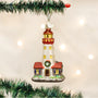 Decorative lighthouse ornament on a Christmas tree with lights in the background