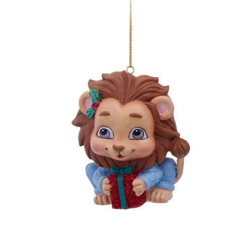 Lion ornament in light blue pajamas, holding a red glittered present and wearing a holly accent near one ear.