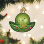 Green glass ornament shaped like a peapod with a bow, hanging on a Christmas tree.