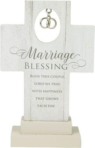 White freestanding cross with silver intertwined rings and the words “Marriage Blessing” above a printed blessing for a couple.