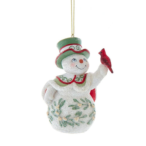 Snowman ornament with a green top hat and mistletoe detailing, holding a red cardinal in one hand.