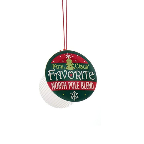 Coffee pod ornament with a green and red label reading “Mrs. Claus’ Favorite North Pole Blend” hanging from a red cord.