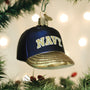 Decorative ornament shaped like a navy blue cap with 'NAVY' text, hanging on a Christmas tree.