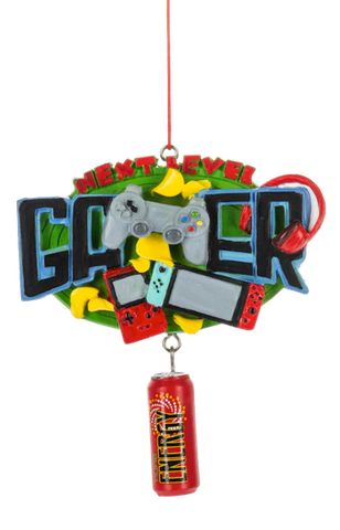 Next Level Gamer ornament featuring bold gamer lettering, video game controllers, a handheld console, a headset, and a dangling energy drink can.