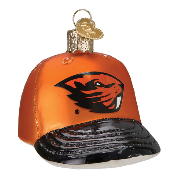 Glass ornament shaped like a baseball cap with a logo on an orange background