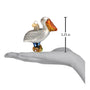 Glass pelican ornament on a hand with measurement label