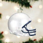 Glass Penn State football helmet ornament on a Christmas tree with blurred lights in the background