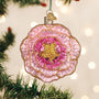 Decorative pink and gold peony ornament on a tree with blurred lights in the background