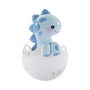 Blue baby brontosaurus ornament sitting in a white dinosaur egg shell with blue accents and a smiling face.