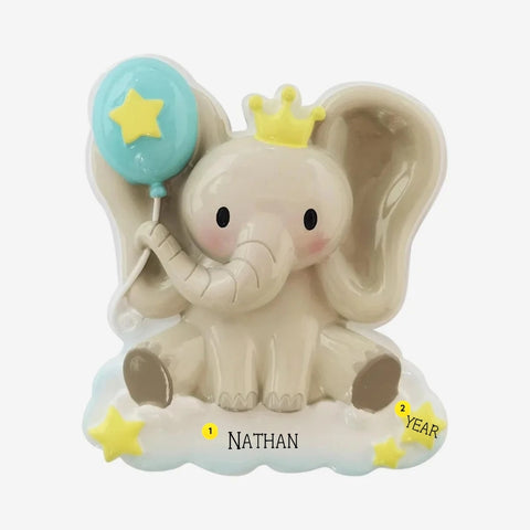 Personalized baby elephant ornament with a yellow crown, blue star balloon, cloud base, yellow stars, and name and year personalization.