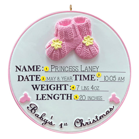 Decorative ornament with pink baby booties and birth details on a white background