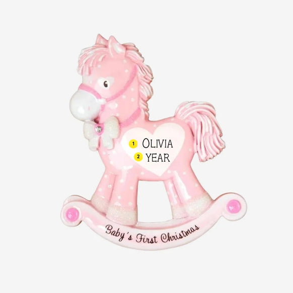 Personalized baby girl’s first Christmas pink rocking horse ornament with a name and year added to the white heart on the side.