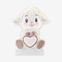 Baby lamb ornament holding a white heart with gold glitter trim and sitting on a white base.