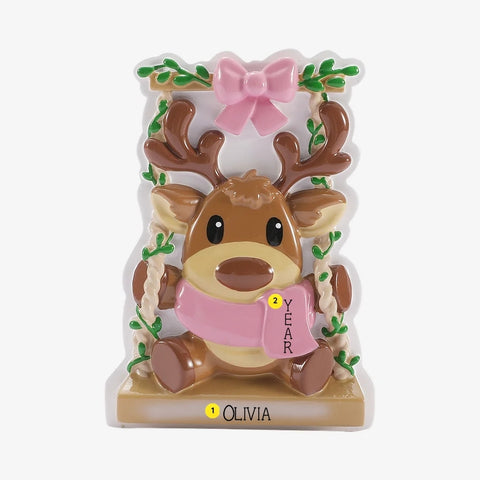Personalized baby reindeer on swing ornament with name on the base and year placement on the pink scarf.