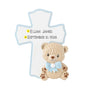 Personalized baby blue cross ornament with a child’s name and date added above a plush teddy bear with a blue bow.
