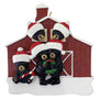 Decorative ornament with 5 black bears wearing Santa hats in front of a red barn.