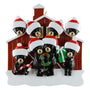 Christmas ornament with 8 black bears wearing Santa hats and winter accessories in front of a red barn.