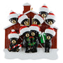 Christmas ornament with black bears in front of a red barn, each bear wearing a Santa hat and holding a gift or candy.