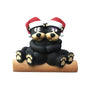 Black bear couple tabletop decoration with two cuddling bears in Santa hats sitting on a log.