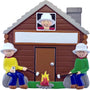 Family ornament with a cabin and family members around a campfire.