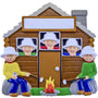Decorative ornament of a cabin with  people by a campfire, featuring smiling faces.