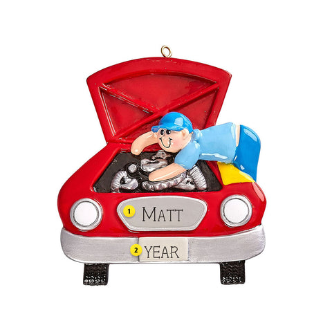  This detailed ornament features a mechanic leaning over the open hood of a classic red car while working on the engine. 